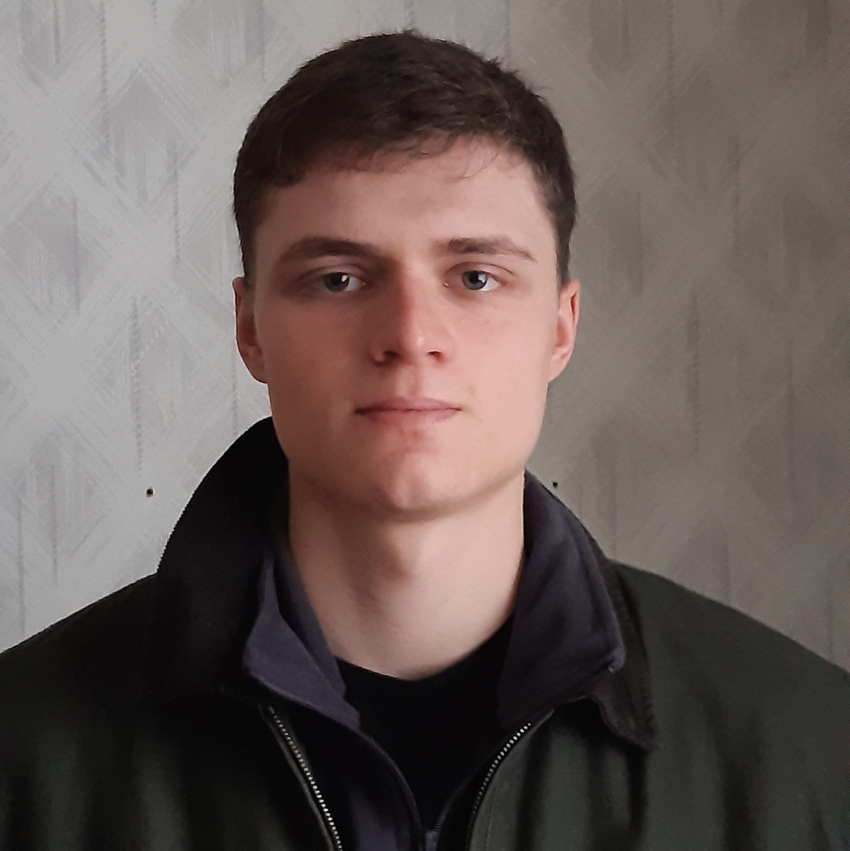 Headshot of Ewan, a white man in his early 20s with short brown hair.