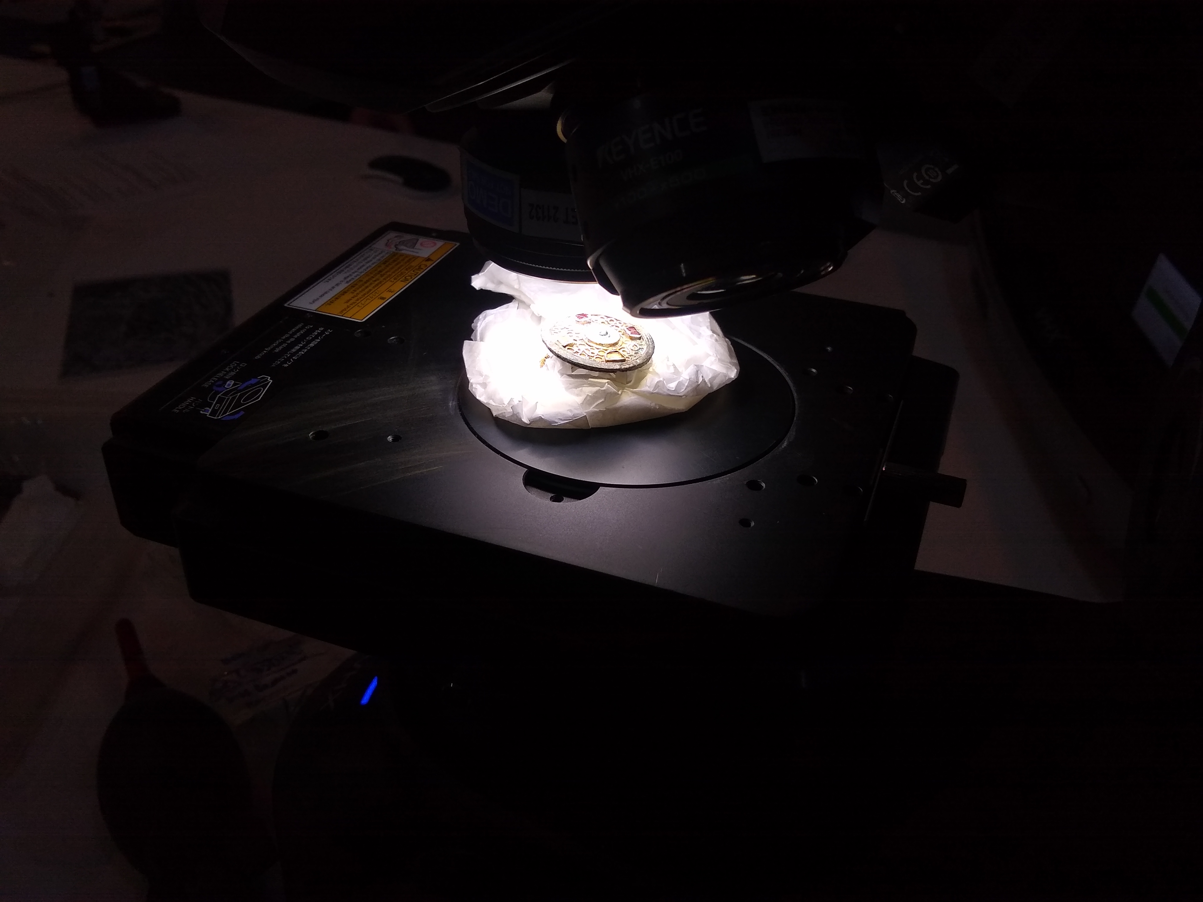 Circular metal brooch with symmetrical design of red gemstones in concentric circles